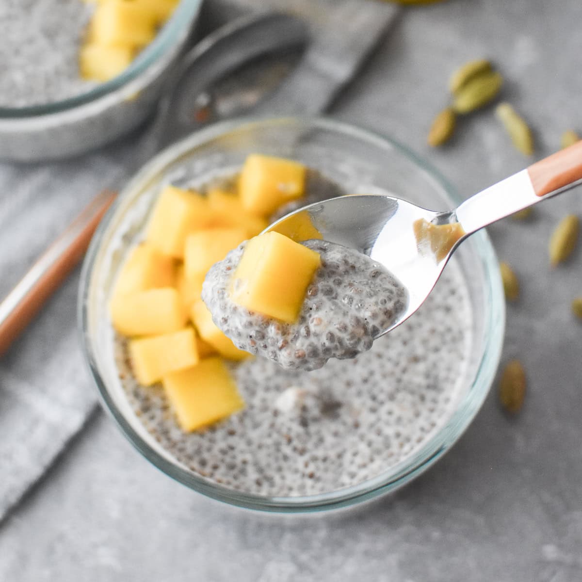 Two glass bowls filled with chia seed pudding and mango.