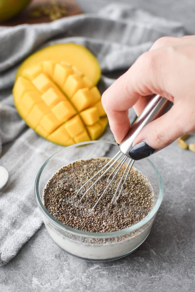 Whisking chia seed pudding together in a glass bowl