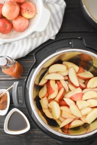 apples in an Instant Pot with spices, cider and maple syrup on the side