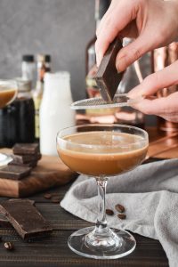 chocolate being grated over a cocktail