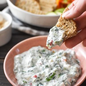 bread being dipped into spinach dip
