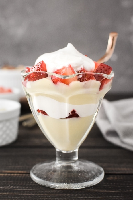 A pudding parfait with berries and whipped cream in a dessert glass