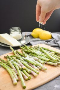 pecorino being sprinkled on asparagus
