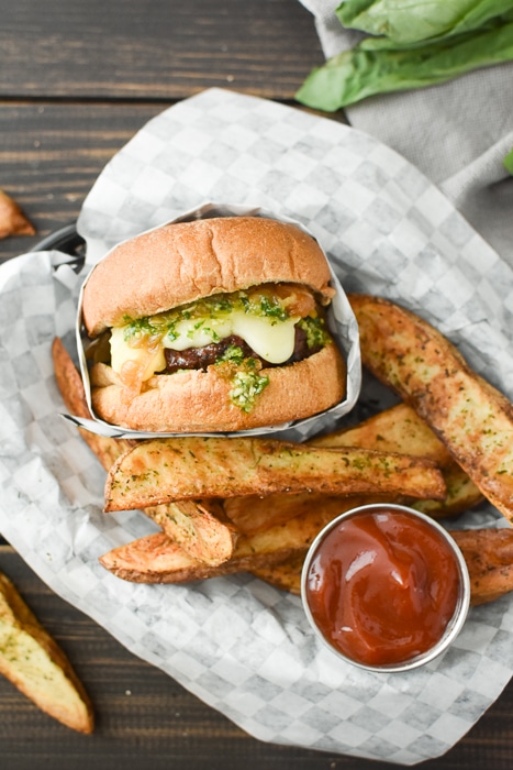a cheesy burger with potato wedges in a basket