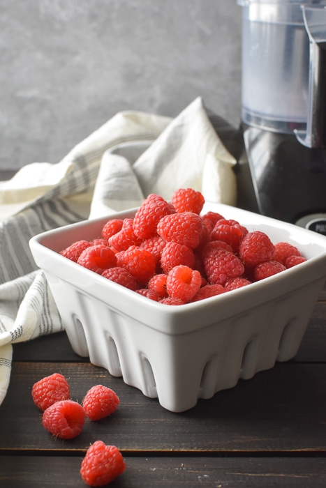 a square dish full of raspberries