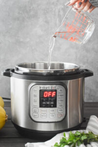 Adding water to an Instant Pot.