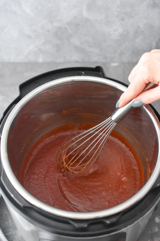 Whisking BBQ sauce in an Instant Pot.