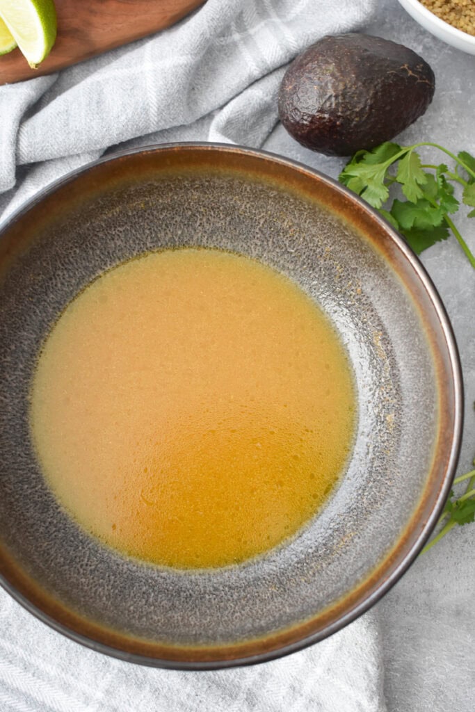 Lime dressing in a large brown bowl.