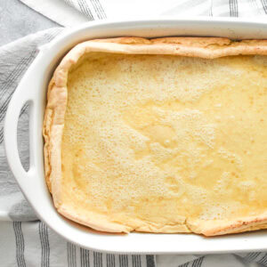 A German Pancake in a white 9 by 13 ceramic casserole dish.